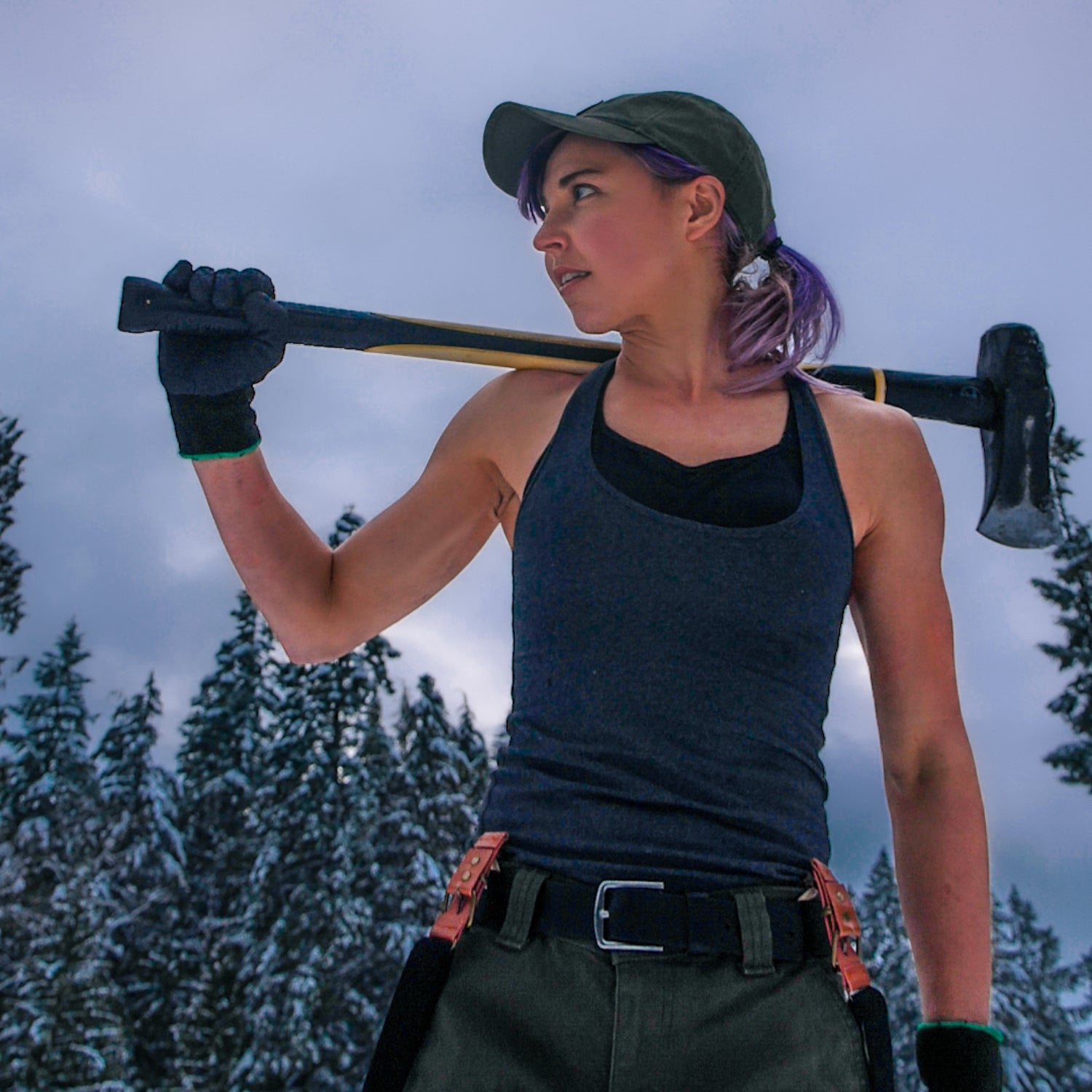 Nicole Coenen, the "lesbian lumberjack of the internet", carries a splitting axe over her shoulder.