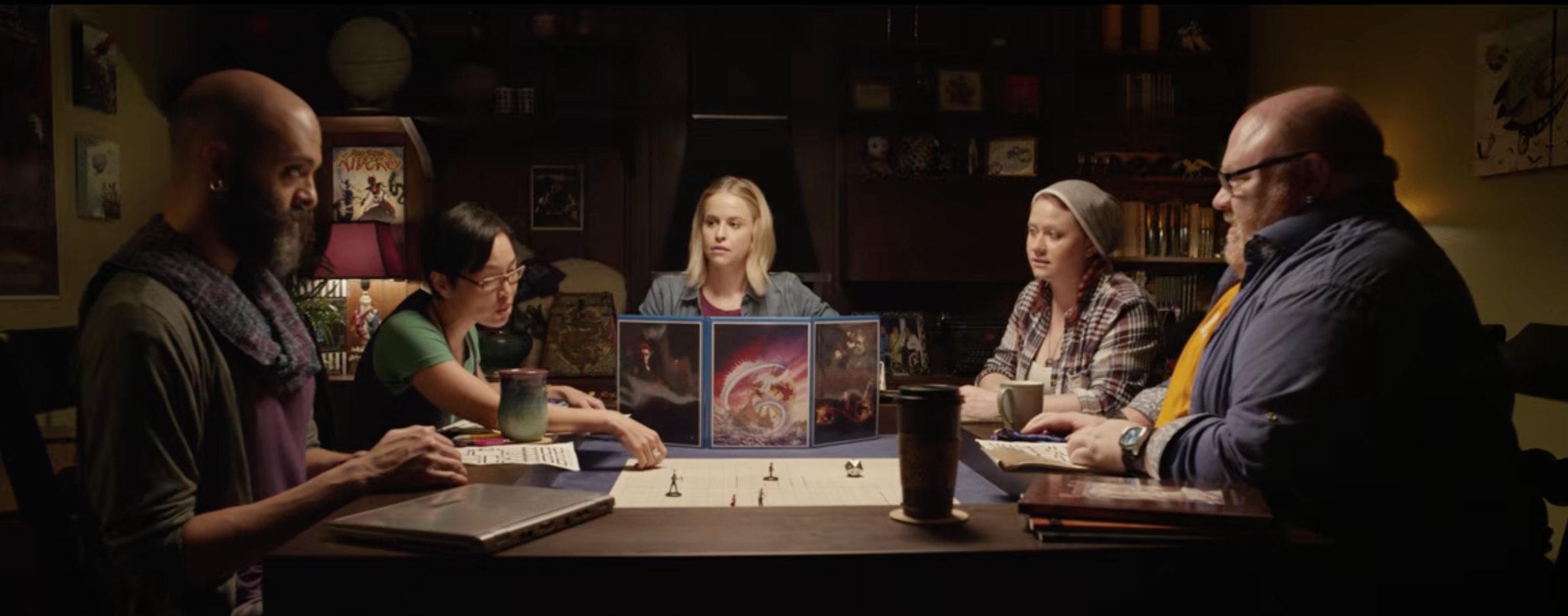 A group of five people gather around a table playing D&Dgroup